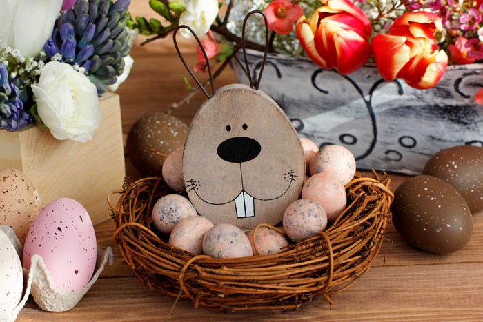 Easter eggs and bunny decoration in a nest with flowers