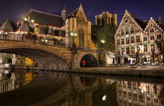 Historic buildings and bridge over canal at night in Belgium
