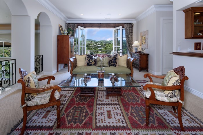 Living room with sofa, chairs, and balcony view
