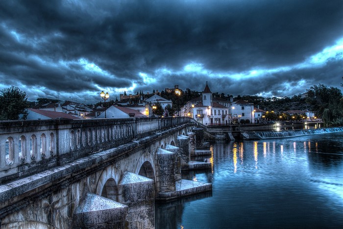 Stone bridge over a river in Santarem, Portugal at night