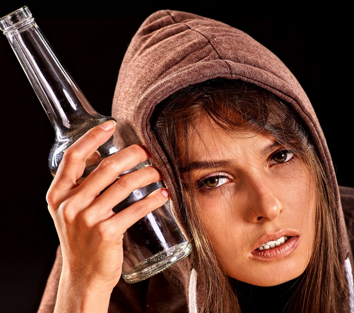 Woman in Hood Holding Empty Bottle