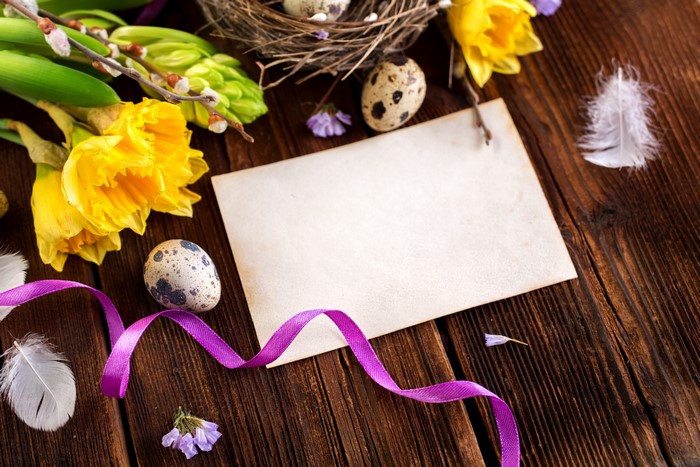 Easter greeting card with daffodils, eggs, and ribbon