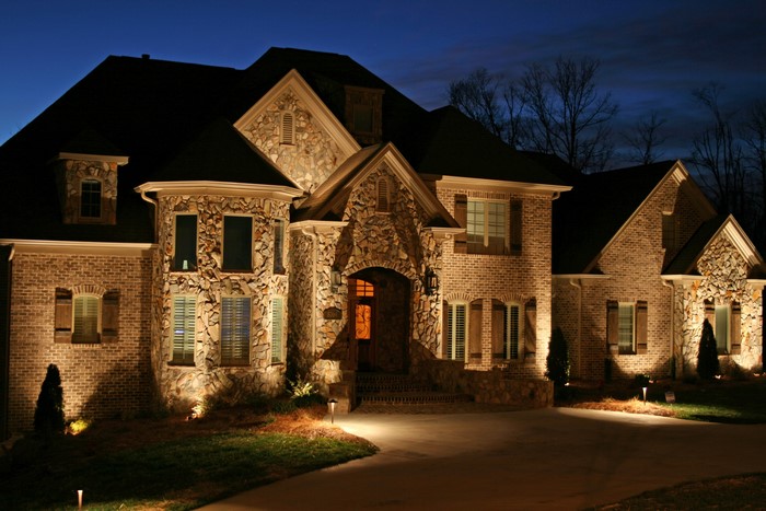 Luxury brick and stone house illuminated at night