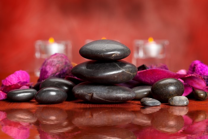 Spa stones and candles with red background