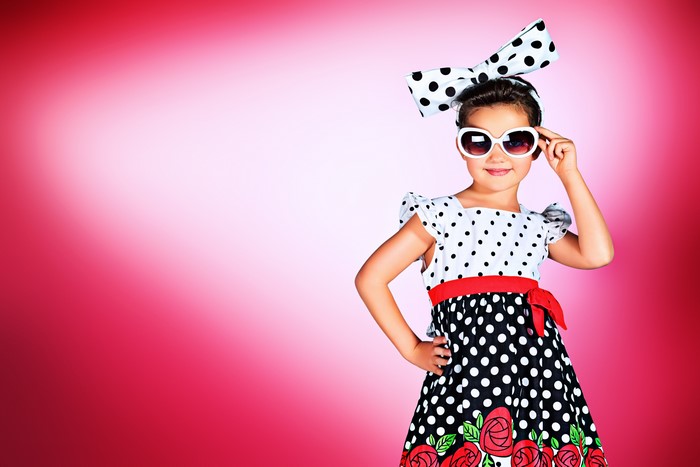 Girl in polka dot dress and sunglasses with bow