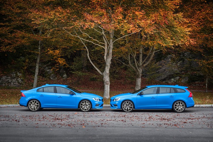 Two blue Volvo cars parked on a road