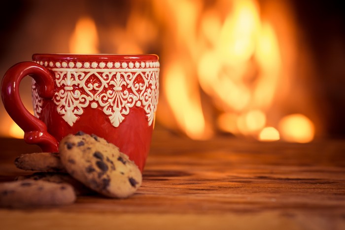 Red mug with cookies by fireplace