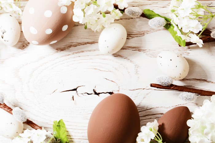 Easter eggs and flowers on a wooden surface