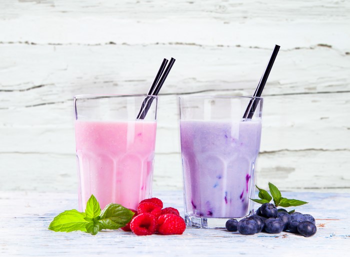 Two berry milkshakes with raspberries and blueberries
