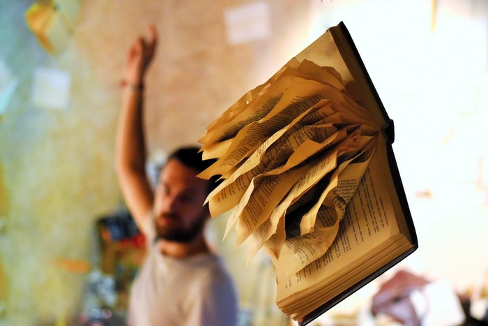 Man with a book with flying pages