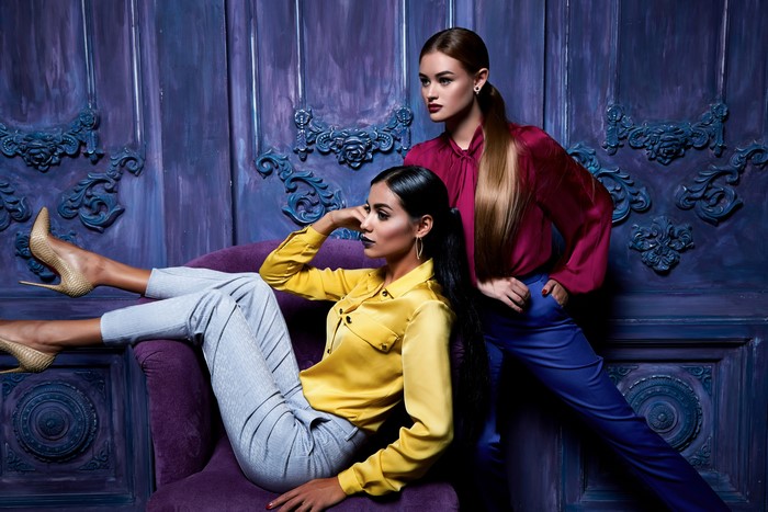 Two women posing in stylish outfits