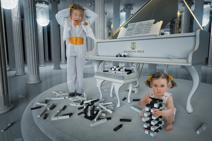 Two little girls with a piano and dominoes