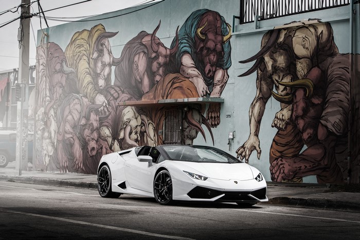 White Lamborghini Huracan parked in front of graffiti mural