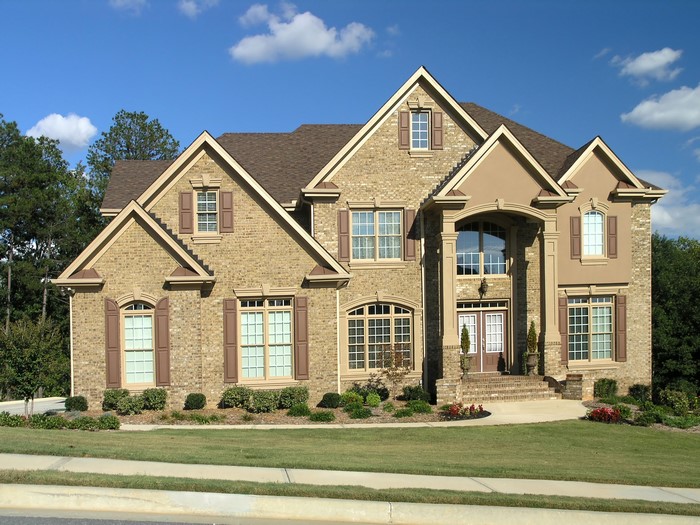 Large brick house with arched windows and a covered entryway