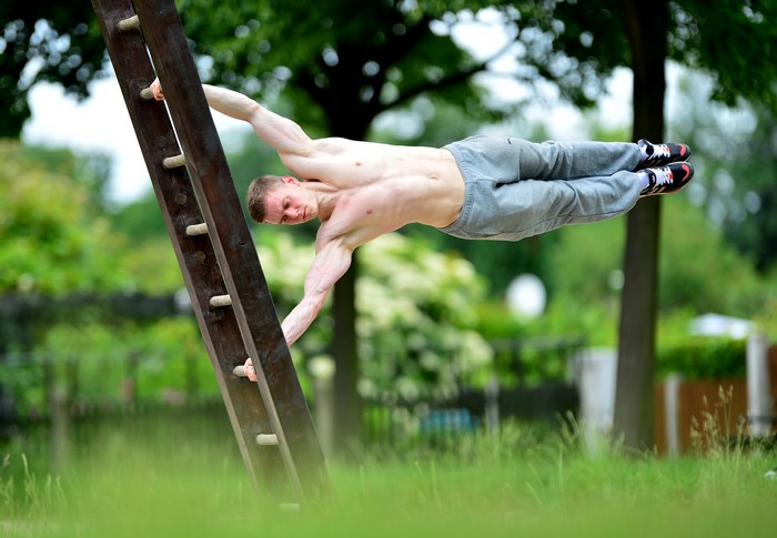 Man performing a human flag on a ladder