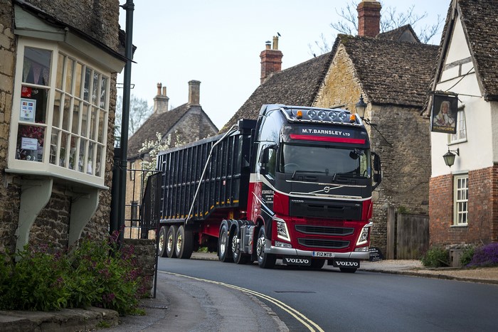 Volvo truck driving through a village