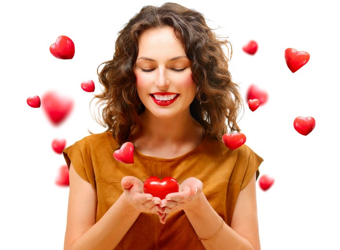 Woman holding a heart with hearts floating around her