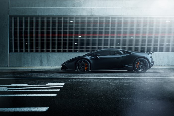 Black Lamborghini Huracan parked on wet asphalt