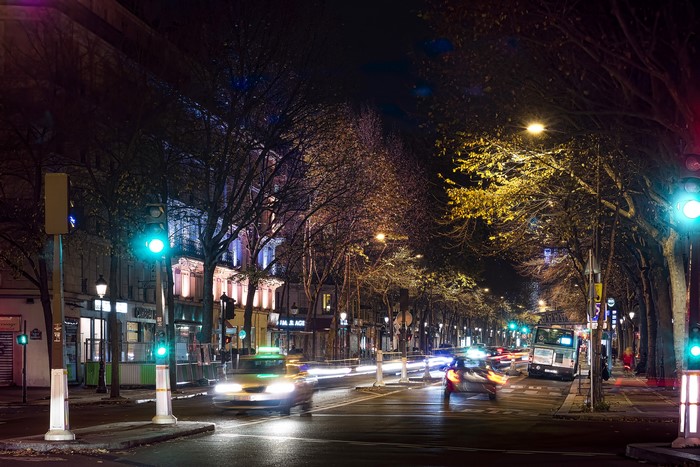 Paris street at night with traffic and trees