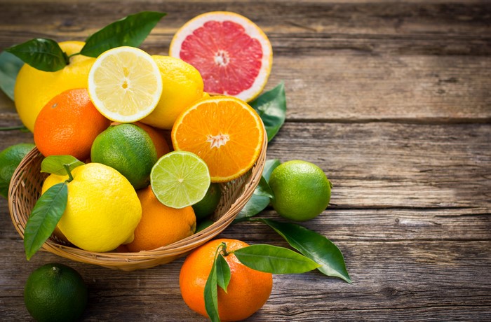 Citrus fruits in a basket on a wooden table