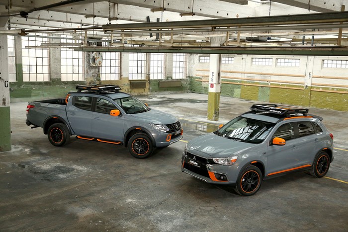 Two grey Mitsubishi vehicles with orange accents in a warehouse