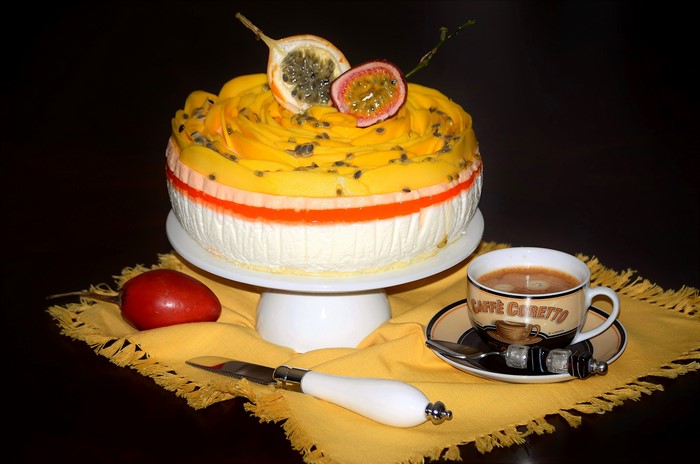 Cake with passion fruit and mango, cup of coffee