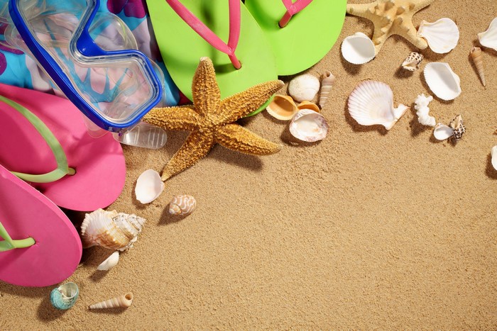 Beach scene with flip-flops, snorkel mask, starfish, and shells