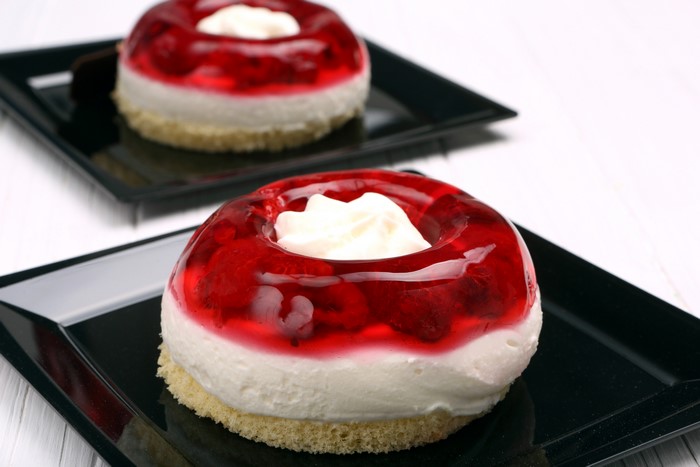 Two gelatin desserts with cream on black plates
