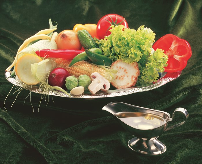 Vegetables on a platter with gravy boat