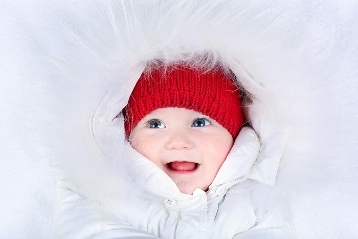 Baby in a red hat and white fur-lined coat