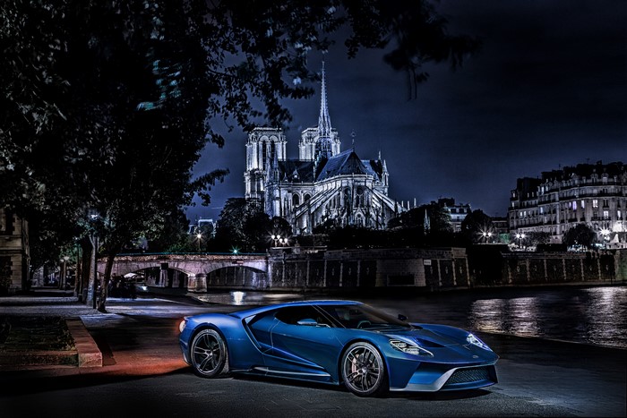 Blue Ford GT parked at night near Notre Dame Cathedral