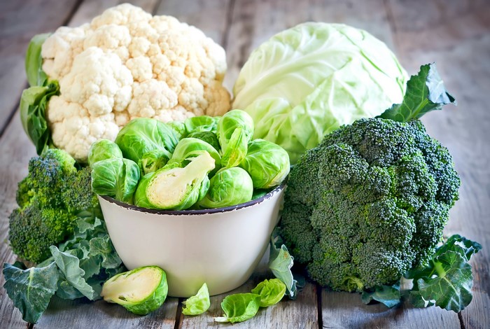 Assortment of fresh vegetables including broccoli, cauliflower, cabbage, and Brussels sprouts