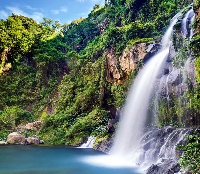 Waterfall cascading down a rocky cliff into a blue pool