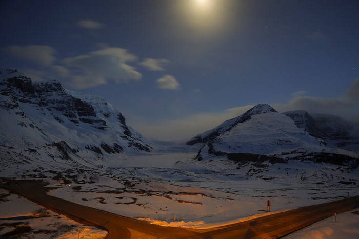 Snowy Mountains and Road Under Moonlight in Jasper National Park