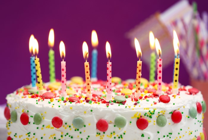 Birthday cake with lit candles and sprinkles