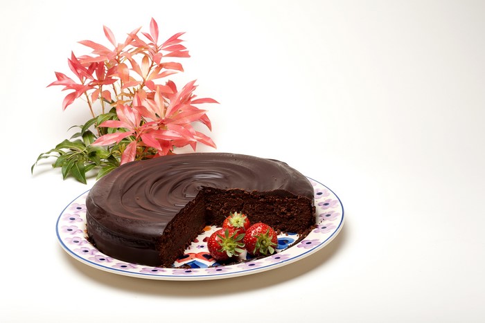 Chocolate cake with strawberries and pink leaves