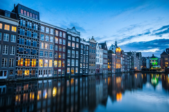 Amsterdam canal houses at dusk with reflections