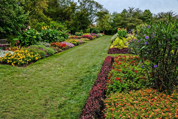 Garden path with colorful flower beds and green lawn