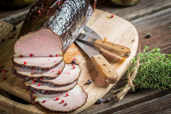 Smoked ham with peppercorns on a cutting board