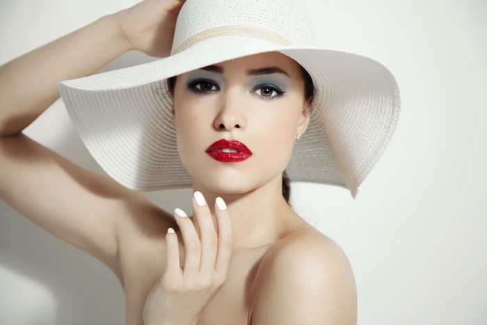 Woman in a white hat with red lipstick