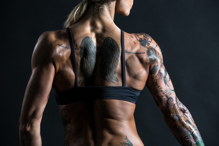 Woman's muscular back with tattoos