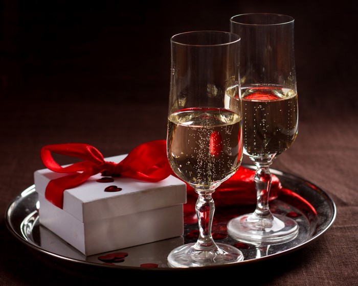 Two glasses of champagne with a gift box