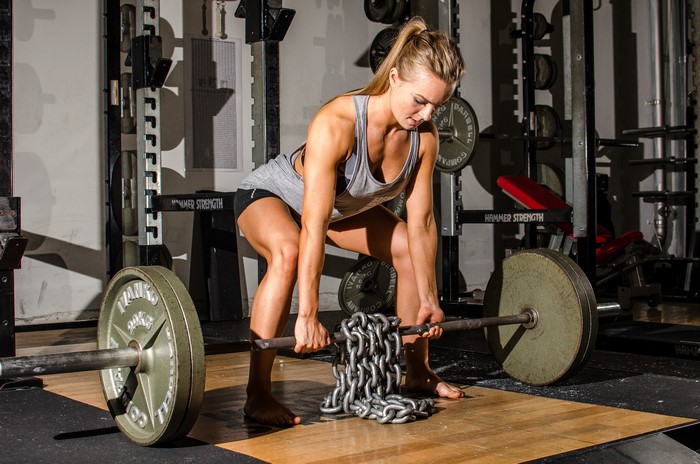 Woman lifting barbell with chains