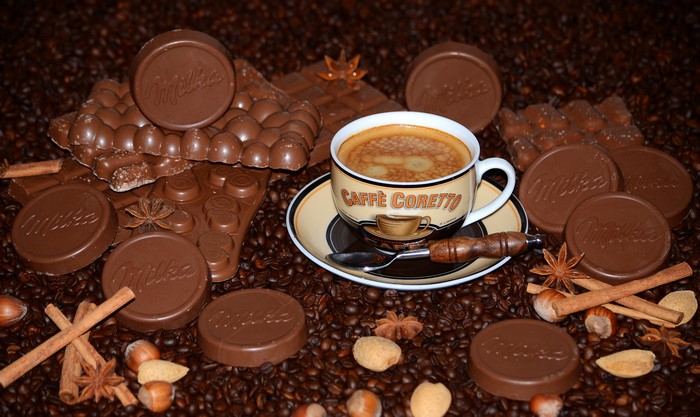 Coffee cup with Milka chocolates and coffee beans
