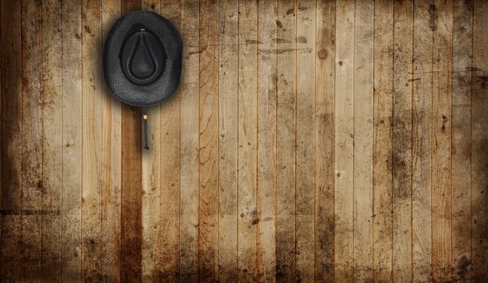 Black cowboy hat on a wooden wall