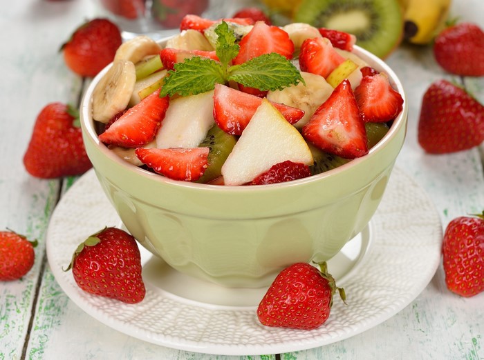 Fruit salad with strawberries, bananas, kiwi, and mint