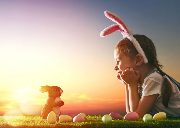 Girl with bunny ears and Easter eggs at sunset