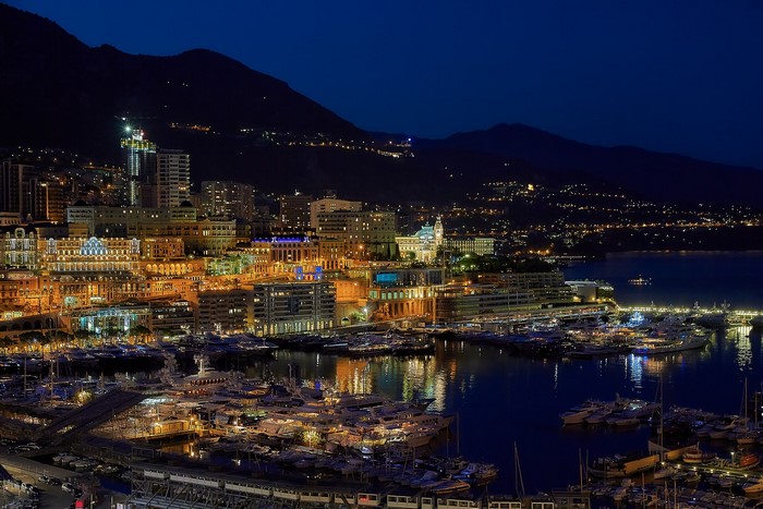 Night view of Monte Carlo harbor with yachts and city lights