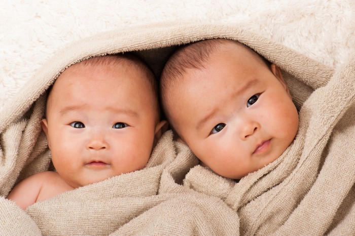 Two infants wrapped in a blanket