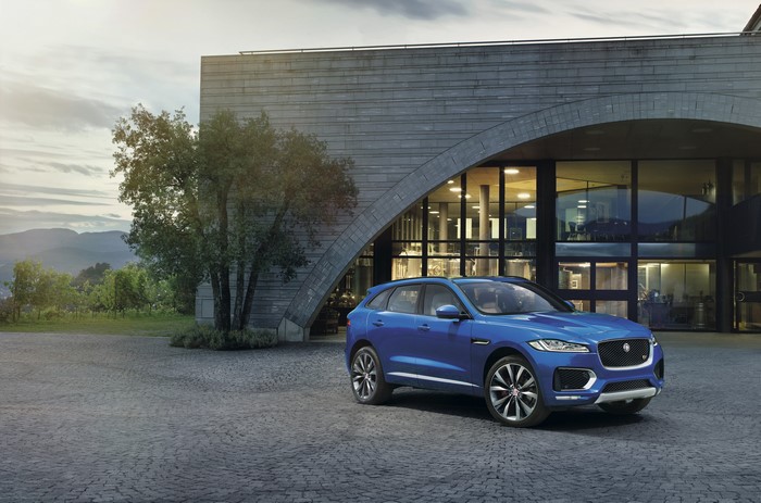 Blue Jaguar F-Pace S parked in front of modern building